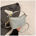 Dettaglio della texture in pelle intrecciata grigio-azzurra con zip dorata e tracolla - Blu
