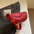 Detailed view of red lychee grain leather crossbody saddle bag with gold metal hardware - Red