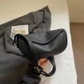 Detail of black litchi grain leather crescent bag with adjustable strap and gold hardware - Black