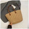Detalle del bolso tote de paja tejida con asa de cuero y diseño de patrón calado - Caqui