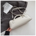 Minimalist beige baguette bag with double handles and silver hardware on neutral background - White