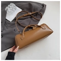 Brown leather baguette bag with dual zippers and adjustable strap on a gray blazer - Brown