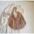 Dettaglio borsa tote intrecciata boho con nappe colorate su vestito estivo bianco - Cachi