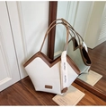 Dettaglio di grande borsa tote in pelle crema con finiture marroni e scollo a V geometrico - Bianco e Marrone