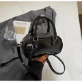 Detailansicht der schwarzen Boston-Tasche aus Lackleder mit weißem Logo und Glanz - Schwarz