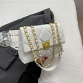 Chic white quilted crossbody bag with gold chain strap on a grey suit background - White