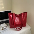 Detail of red crocodile texture on large tote bag with shiny finish and shoulder straps - Burgundy