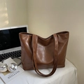 Dettaglio di una grande borsa tote marrone a trama coccodrillo su scrivania con laptop - Marrone
