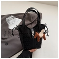 Macro shot of black bucket bag with laser-cut CD motifs and brown pegasus charm - Black
