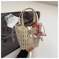Detail of cream white hollow-out bucket bag with laser-cut patterns and pegasus charm - Off White