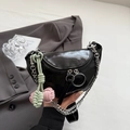 Chique zwarte zadeltas met zilveren ketting en gekleurde knopen op donker pak - Zwart