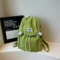 Détail du sac à dos en nylon vert moutarde avec fermeture à rabat et étiquette tissée - Vert