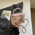 Roze box-tas met zilveren vlinderbedeltjes en metalen ketting in een verfijnde lifestyle-stijl - Roze