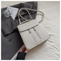Detalle de bolso de cuero crema con doble cremallera sobre fondo de chaqueta formal - Blanco