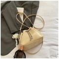 Dettaglio borsa a secchiello beige con catena argento e ciondolo elegante in pizzo e perle - Con Ornamento / Giallo