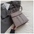 Détail d'un sac à dos en cuir taupe avec fermetures éclair argentées et lettrage - Kaki