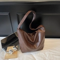 Borsa hobo in morbida pelle marrone con tracolla larga in un contesto elegante - caffè