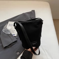 Minimalist black frosted bucket bag with leather strap and logo tag for casual wear - Black