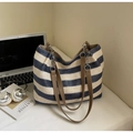 Detail der gewebten Tragetasche in Navy und Beige mit Ledergriffen und Metallkette - Blau