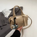 Dettaglio della borsa Boston beige con scritte a rilievo e ciondolo a cavallo blu - Khaki Con Pendente