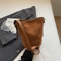 Brown frosted leather bucket bag with adjustable strap on a dark blazer outfit - Brown