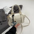 Dettaglio della borsa Boston bianco off-white con goffratura e ciondolo a forma di cavallo - Bianco Con Pendente