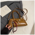Detail of brown vintage patent leather baguette bag with metal buckle and woven charms - Brown with Pendant