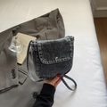 Close-up of vintage grey denim crossbody bag with metal magnetic snap closure - Black