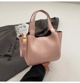 Pink faux leather bucket bag with top handle and gold hardware in stylish urban design - Pink Without Charm
