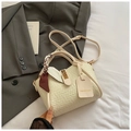 Detail der geflochtenen Handtasche mit dekorativem Seidenschal und goldener Schließe - Gebrochenes Weiß