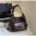 Close-up of retro large tote bag with buckle pocket and smooth brown PU leather texture - Dark Coffee
