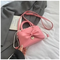 Detalle del bolso rosa con lazo, colgante de corazón plateado y cordón blanco - Rosa