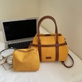 Dettaglio della borsa tote in tela gialla con manici in pelle marrone e pochette - Giallo