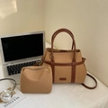 Dettaglio della borsa tote in tela con finiture in pelle e pochette coordinata sulla scrivania - Cachi