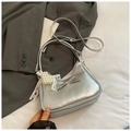 Détail du sac à main argenté métallisé avec nœud décoratif et breloque cœur perle - Argent avec pendentif