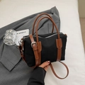 Detail of Boston canvas bag with brown leather handles placed on a grey blazer suit - Black
