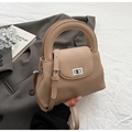 Dettaglio della borsa beige che mostra la pelle motivo litchi e la texture a pieghe verticali - Cachi