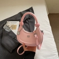 Detail of pink faux leather crescent bag featuring silver heart charm and metal logo - Pink