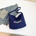 Navy blue canvas tote bag with malivi embroidery on a casual lifestyle background - Dark Blue
