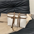 White and brown contrast tote bag with lychee texture leather on black sofa - White