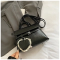 Detail der schwarzen PU-Leder Handtasche mit weißem Spitzenherz-Anhänger und Silberschnalle - Schwarz