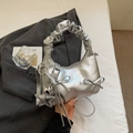 Gedetailleerd overzicht van de zilveren metallic geplooide handtas met strikken en sterren - Zilver