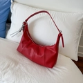 Borsa a tracolla rossa in pelle martellata con ciondolo a nodo argento su letto - Rosso