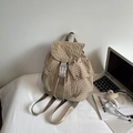 Detailed macro view of beige plaid backpack with white plastic buckle and front pockets - Khaki