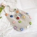 Handgefertigte cremefarbene Häkeltasche mit bunten 3D-Blumen und gewebter Netzstruktur - Cremeweiß