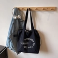 Minimalist black canvas tote bag with white letter print and drawstring closure - Black