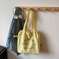 Minimalist bright yellow canvas tote bag with green lettering and adjustable drawstring - Yellow