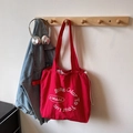 Red canvas tote bag with white circular text print and adjustable drawstring closure - Red