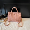 Detail van roze PU-leren draagtas met goudkleurige hardware en schouderband - Roze