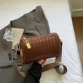 Detail der geflochtenen Leder-Pillow-Bag mit Goldschloss und retro geometrischem Gurt - Braun